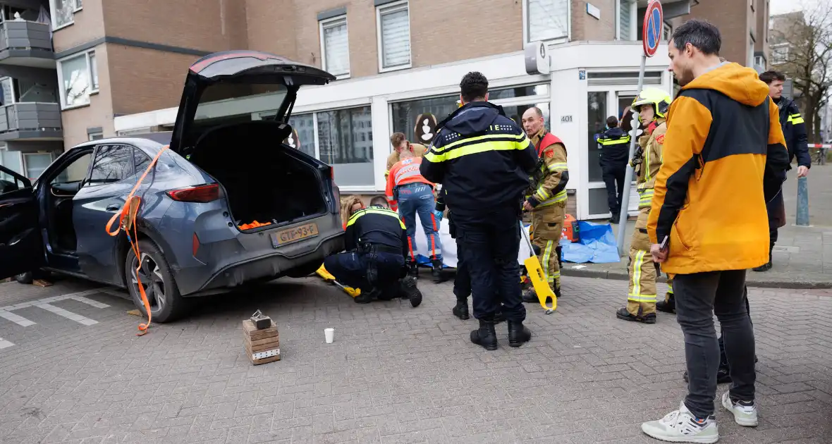 Fietsster bekneld onder auto na aanrijding - Foto 1