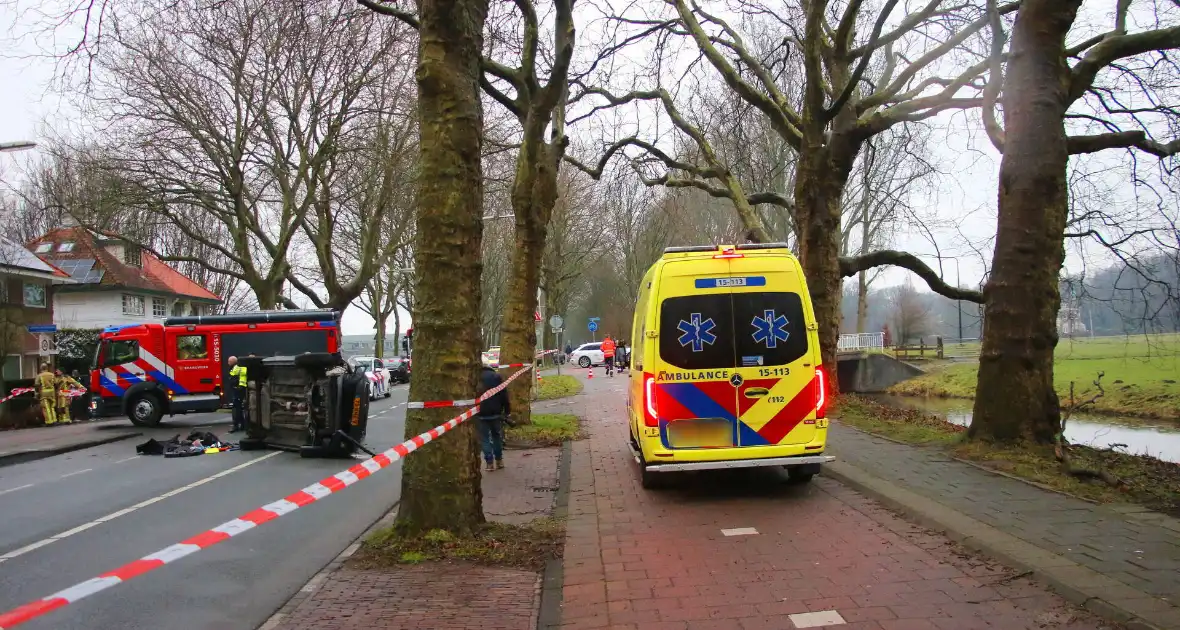 Auto slaat over de kant na botsing tegen boom - Foto 12