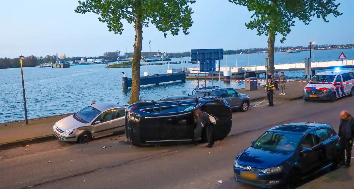 Auto botst op drie geparkeerde auto's en belandt op zijkant