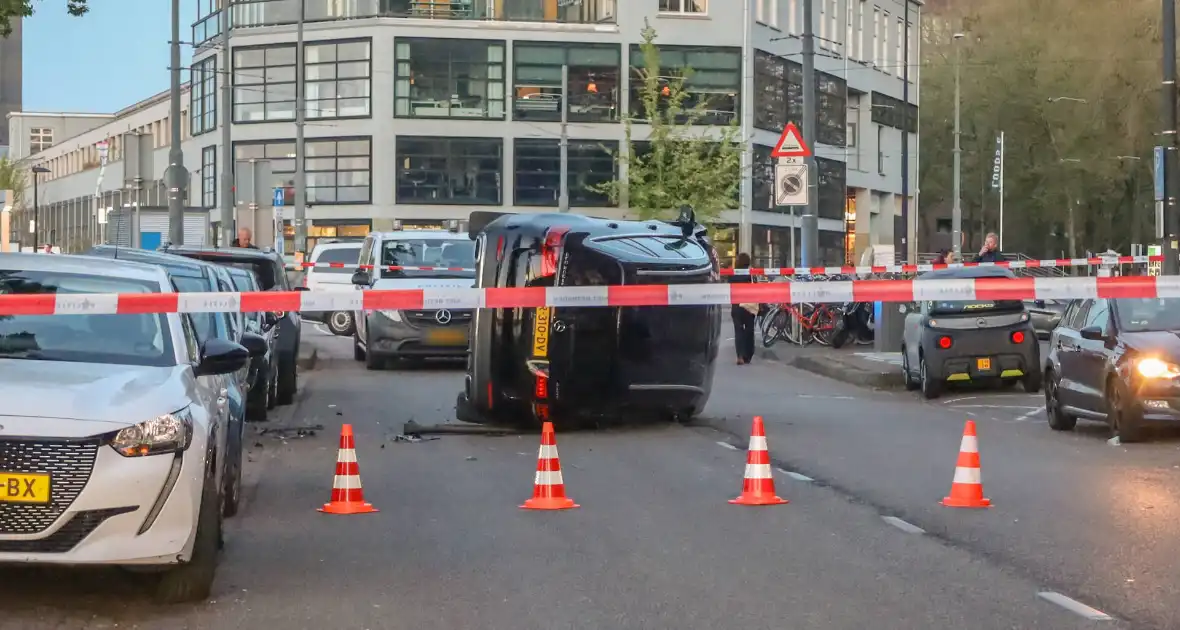 Auto botst op drie geparkeerde auto's en belandt op zijkant - Foto 1