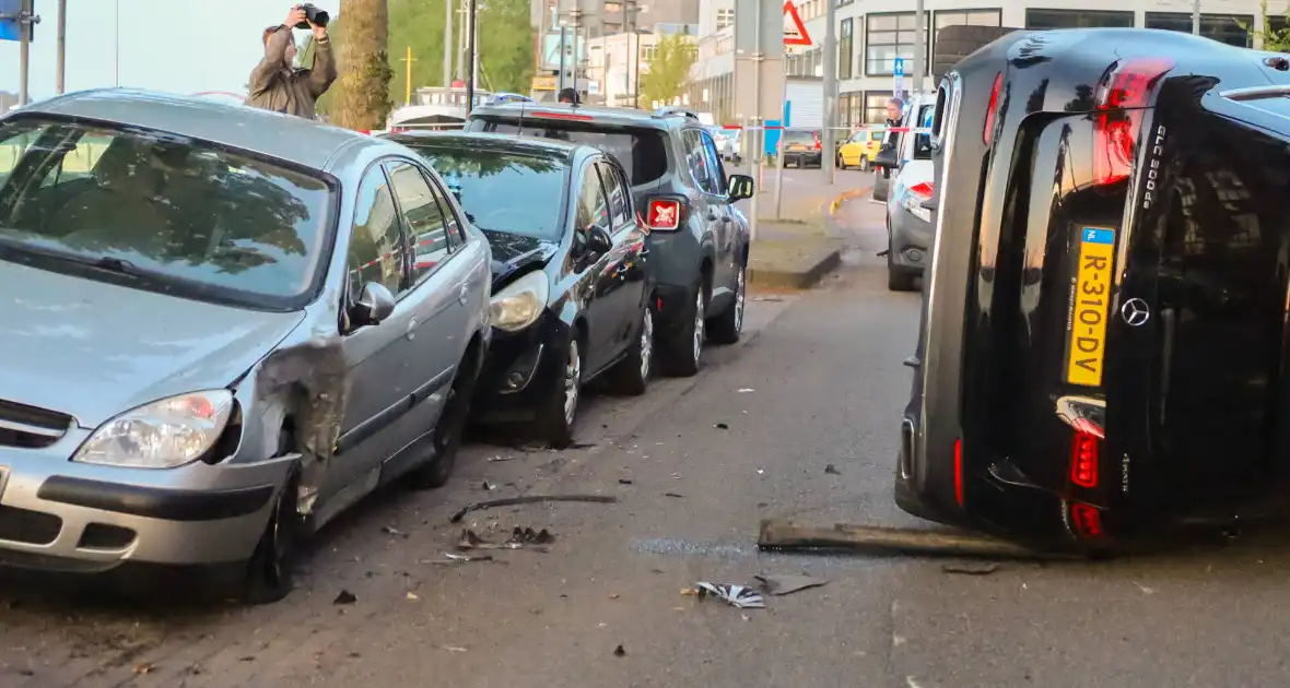 Auto botst op drie geparkeerde auto's en belandt op zijkant - Foto 2