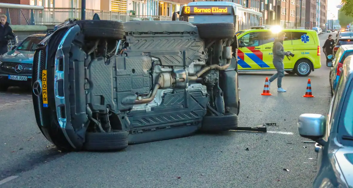 Auto botst op drie geparkeerde auto's en belandt op zijkant - Foto 4