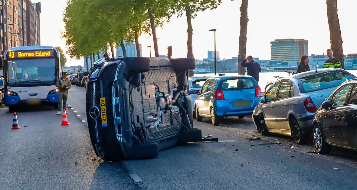Auto botst op drie geparkeerde auto's en belandt op zijkant - Foto 5