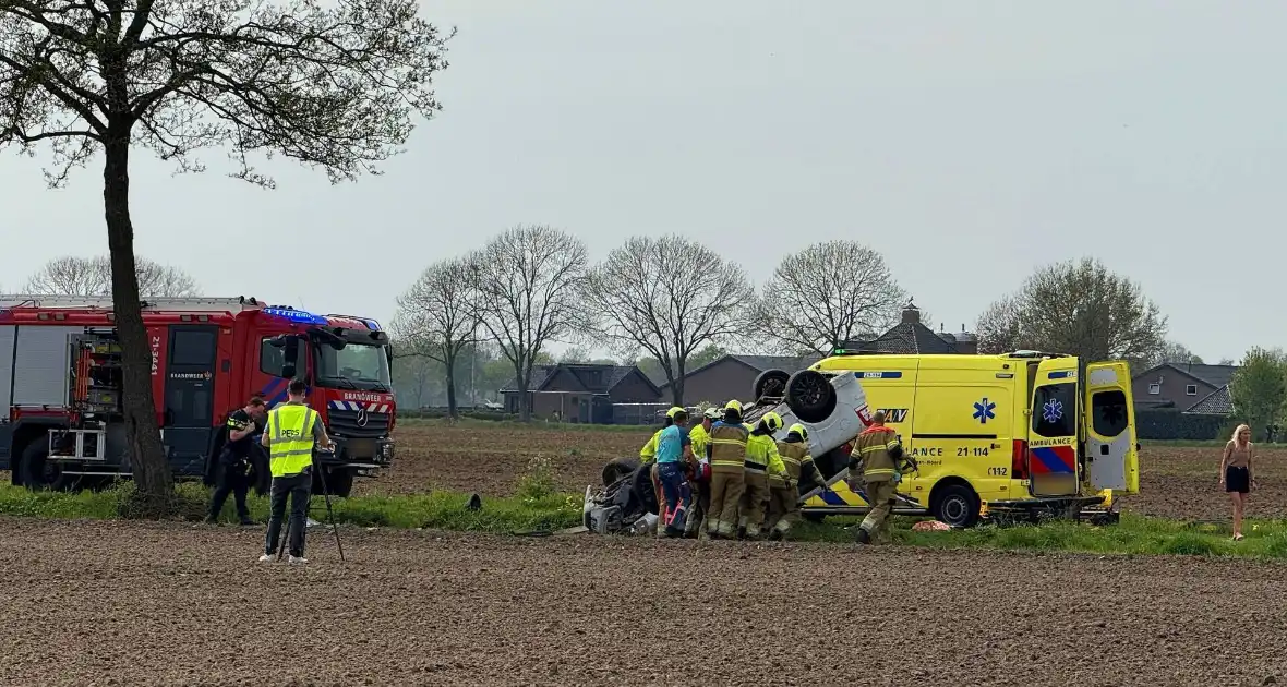 Auto belandt op de kop in weiland