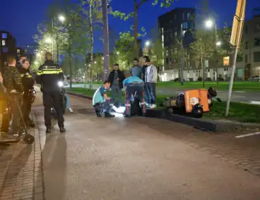 Maaltijdbezorger klapt tegen auto en komt ten val