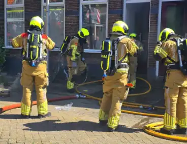 Brandweer slaat raam in wegens brand