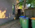 Schutting naast woning in brand