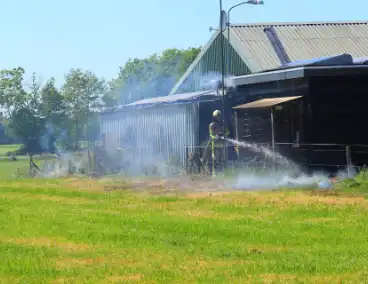 Brand in bosschage slaat over op gebouw