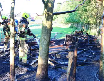 Bomen en pipowagen in brand