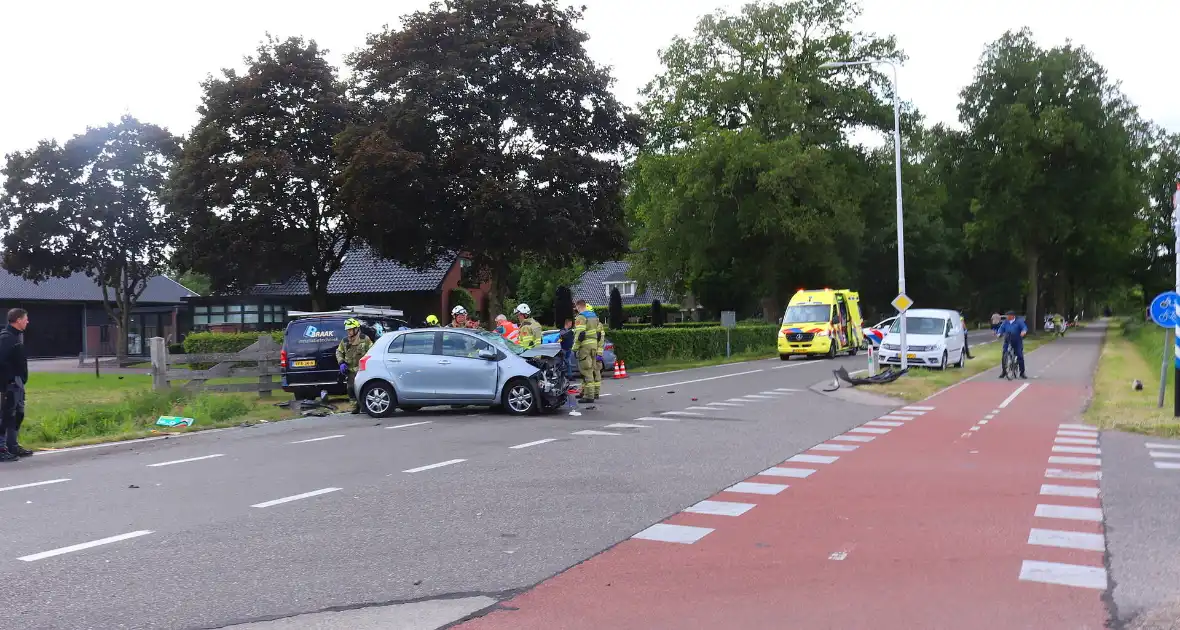 Bestelbus en personenauto met elkaar in botsing, brandweer assisteert bij bevrijding automobilist