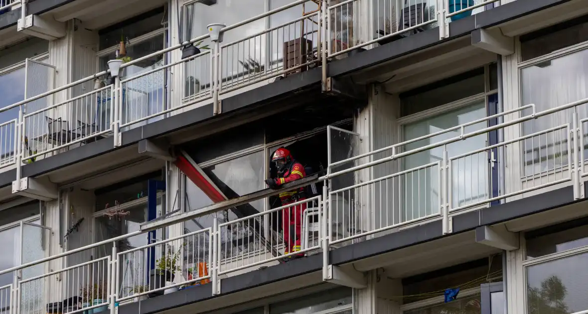 Brandweer druk met grote brand in flatwoning