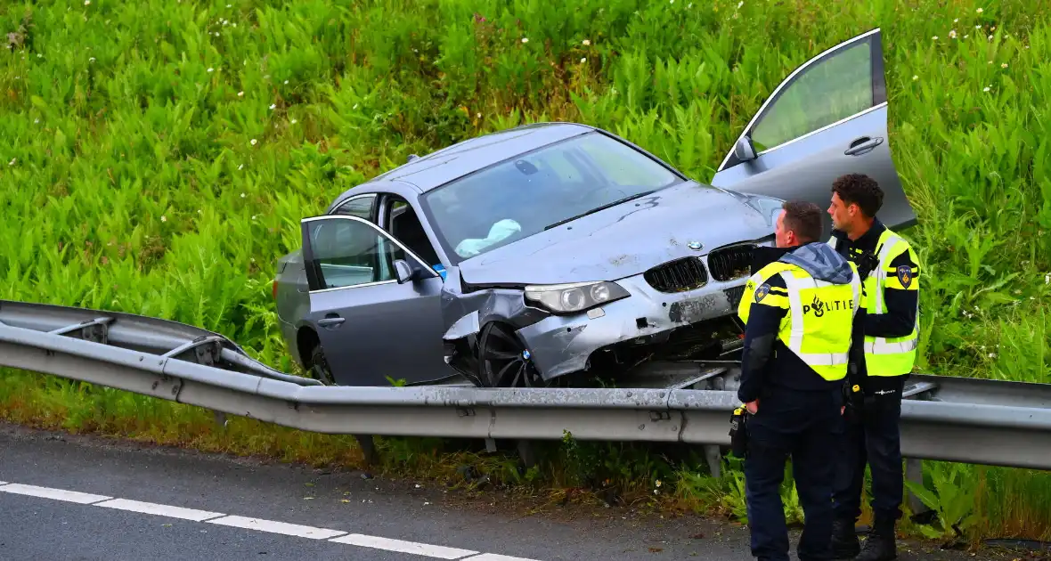 Auto crasht en belandt op vangrail