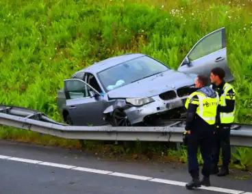 Auto crasht en belandt op vangrail