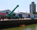Te water geraakte werkbus door kraan uit water gehaalt