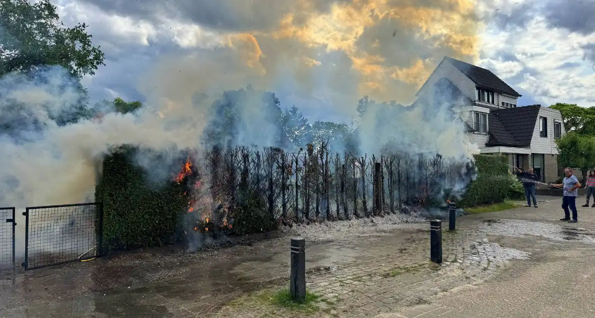 Bewoners blussen met tuinslang - Foto 1