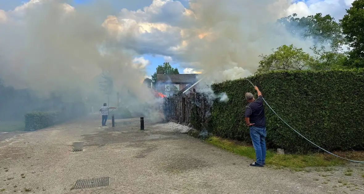 Bewoners blussen met tuinslang - Foto 2