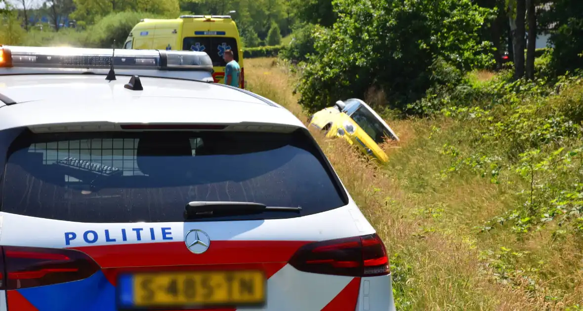 Politie helpt vrouw uit auto - Foto 1