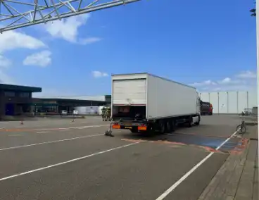 Accu van pallettruck valt om in oplegger