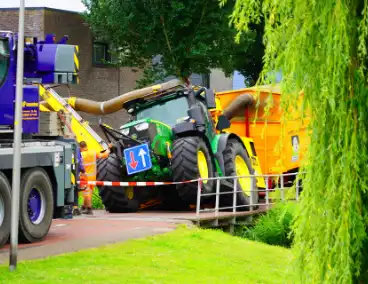 Tractor zakt door brug tijdens werk
