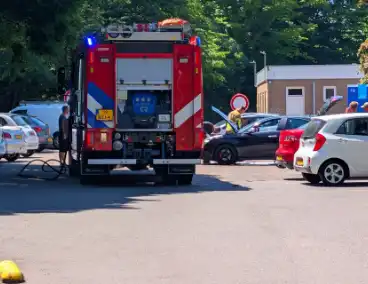Brandweer blust auto op parkeerterrein