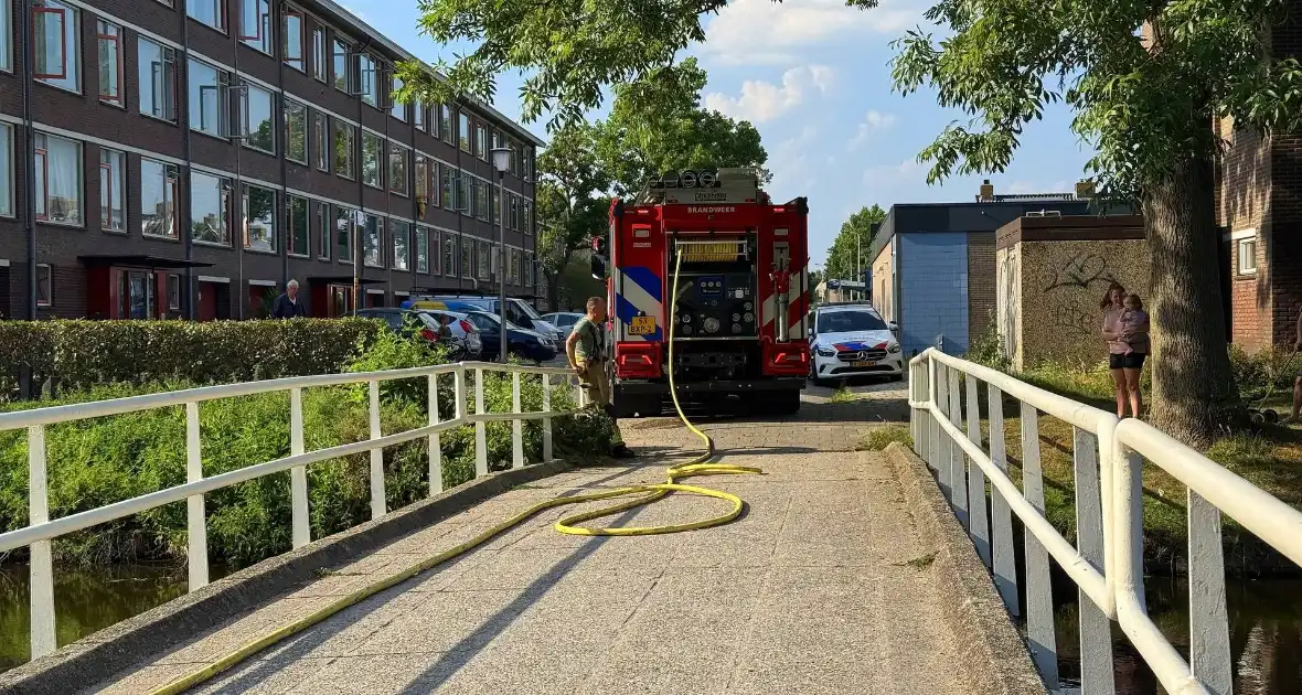 Omstander helpt brandweer met blussen van brand in bosschage - Foto 1