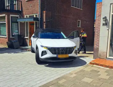 Auto rijdt achteruit tegen woning