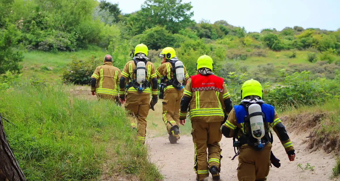 Omstanders blussen brand in duingebied - Foto 1