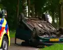 Auto over de kop na botsing