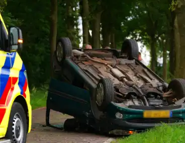 Auto over de kop na botsing