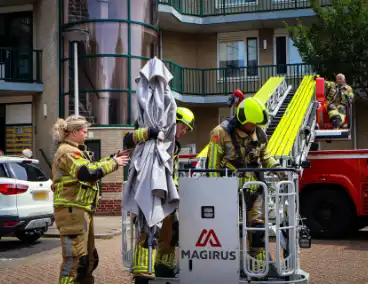 Los gewaaide parasol belandt op dak appartementencomplex