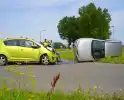 Auto belandt op zijkant na botsing, bestuurder aangehouden