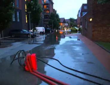 Parkeerplaats onder water na wolkbreuk