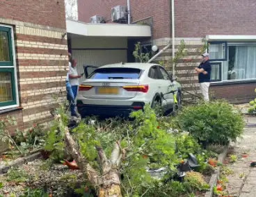 Voertuig ramt boom en huis