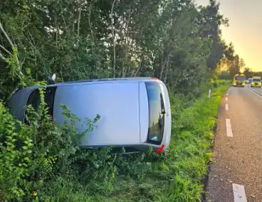 Auto kantelt in bosschages