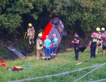 Auto rijdt van dijk af en slaat voorover