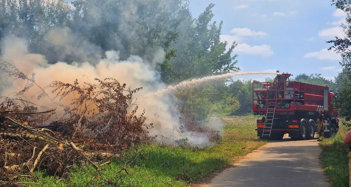 Stapel gesnoeid hout in brand - Foto 1