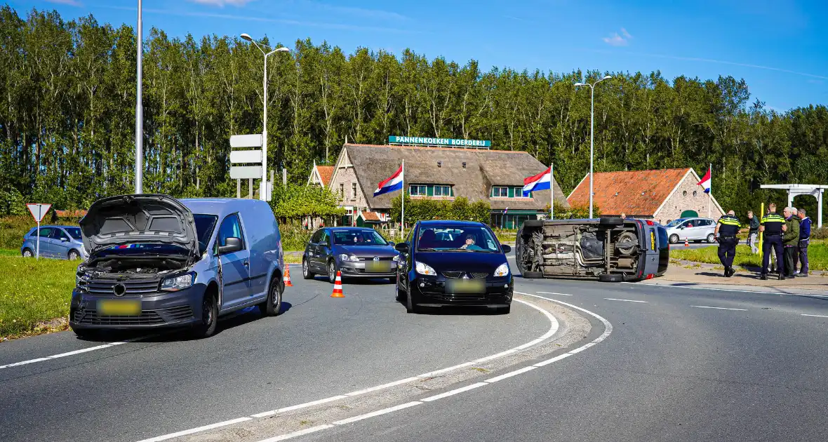 Bestelbus op zijn kant na botsing