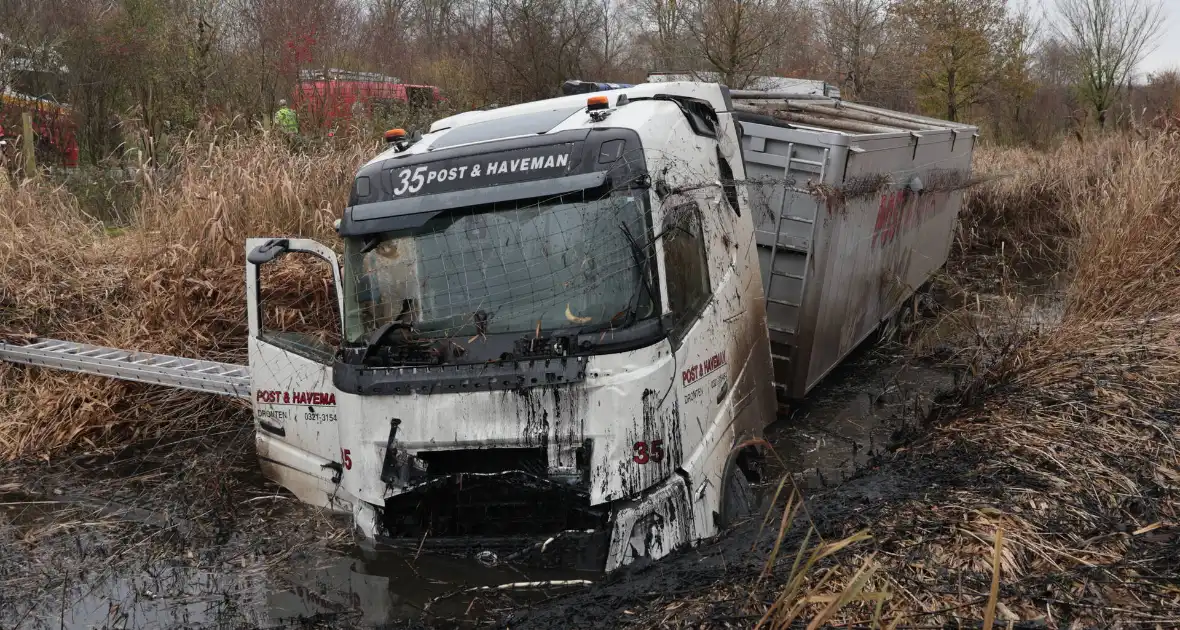 Vrachtwagen belandt in sloot, bestuurder bevrijdt - Foto 1