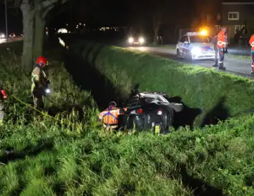 Auto belandt op zijkant in sloot