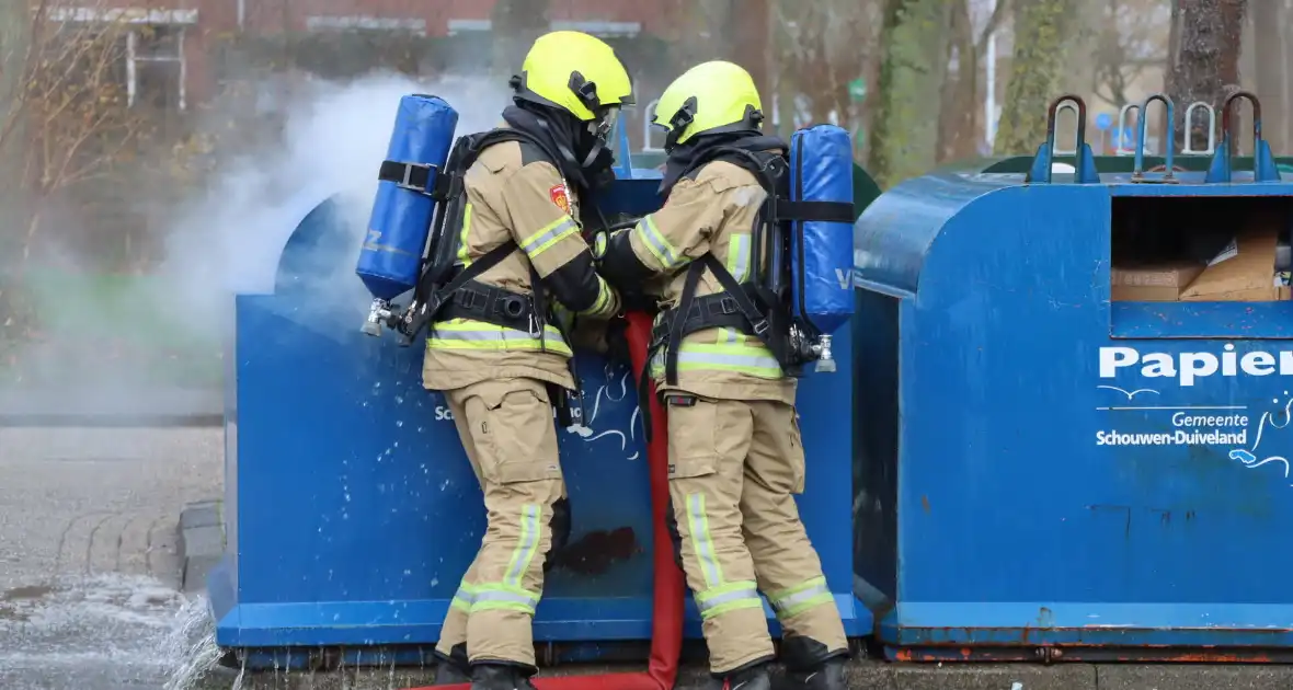 Brandweer dooft brand in papiercontainer