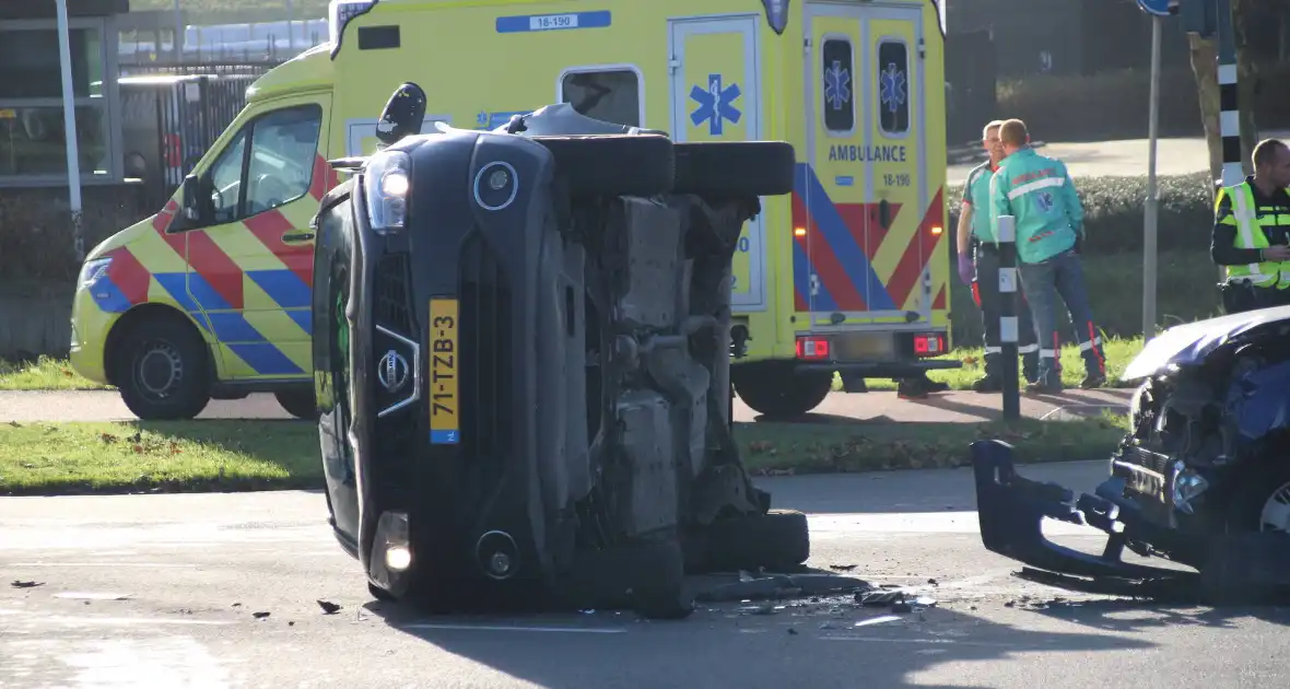 Zwaar ongeval tussen twee auto's met voertuig op zijn kant - Foto 1