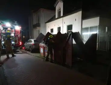 Omwoners starten met blussing van containerbrand