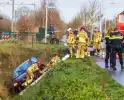 Auto op zijkant in greppel na ongeval