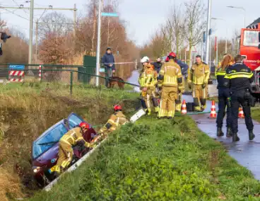 Auto op zijkant in greppel na ongeval