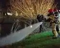 Brandweer blust brand langs sloot