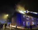 Rookwolken stijgen uit dak van woning