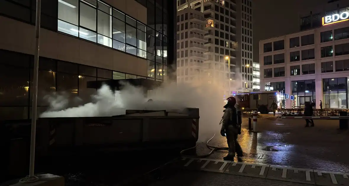 Bouwcontainer in brand vlakbij gebouw