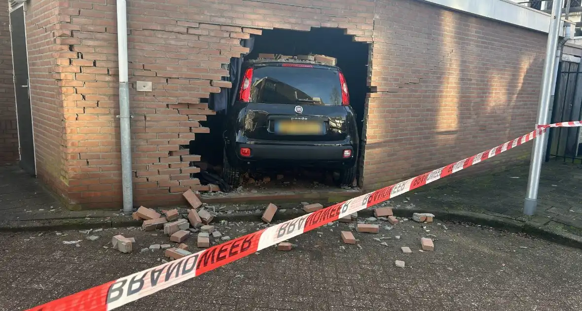 Vrouw rijdt dwars door muur van schuur