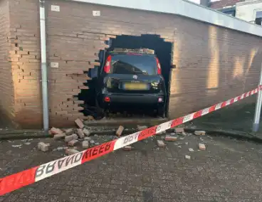 Vrouw rijdt dwars door muur van schuur