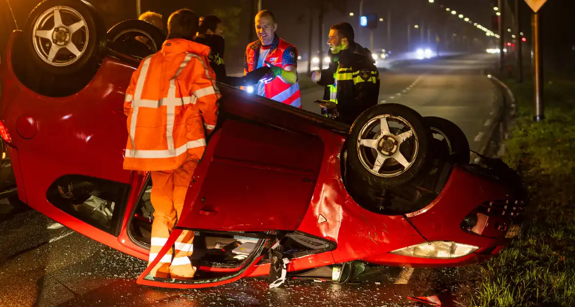 Auto over de kop na ongeval op kruispunt - Foto 1